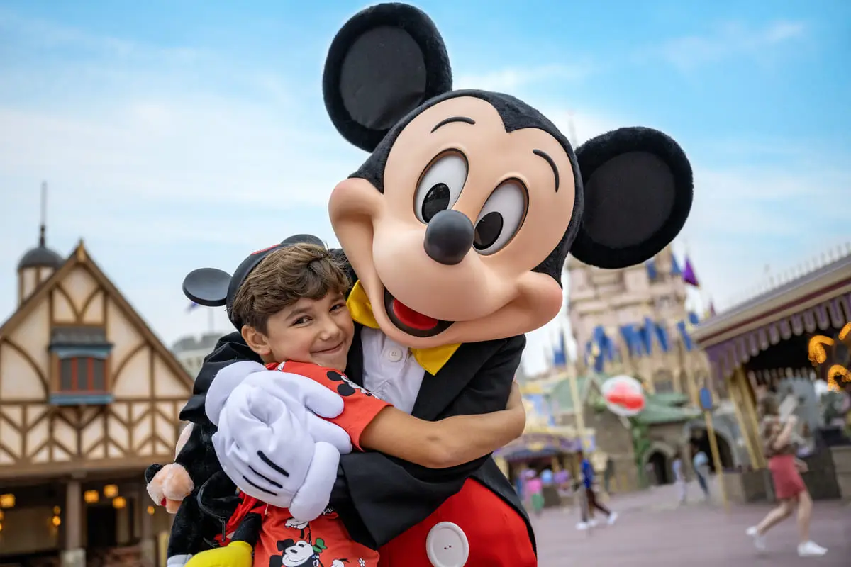 disney-resorts - Best Travel Agents in NJ - JJ Travel Associates Child getting a hug from Mickey Mouse at Magic Kingdom