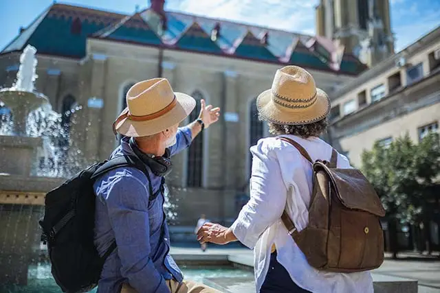 Senior couple exploring their roots - Best Travel Agents in NJ - JJ Travel Associates Couple looking at buildings in a neighborhood