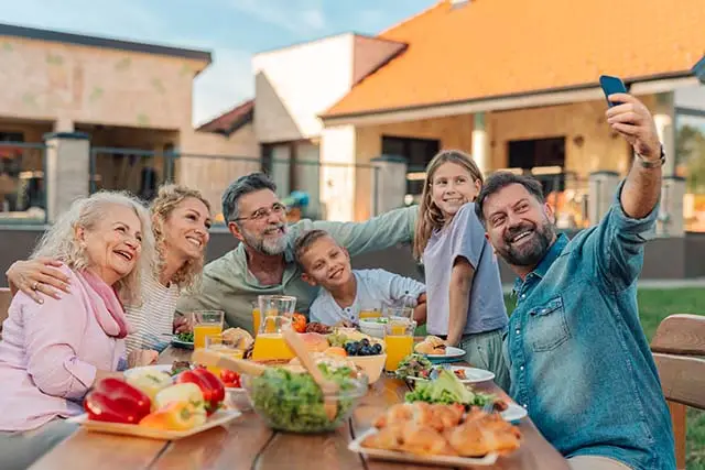 Happy multi generational family - Best Travel Agents in NJ - JJ Travel Associates Multi generational family enjoying a meal on vacation