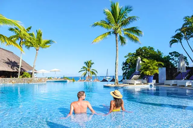 Man and Woman relaxing in a pool on vacation - Best Travel Agents in NJ - JJ Travel Associates Couple relaxing in a beautiful pool in the Caribbean