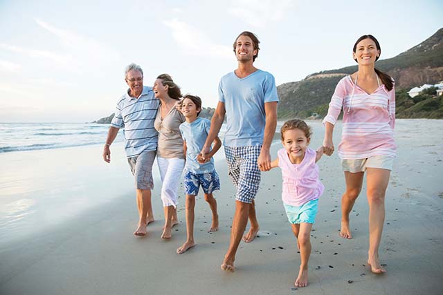 Multi generation family walking on a beach while on vacation