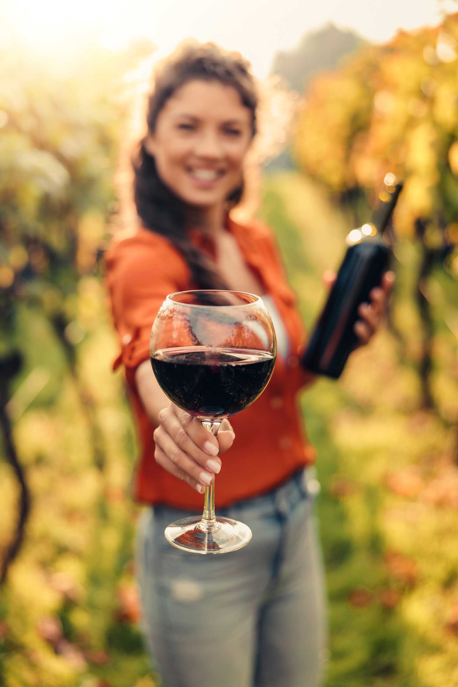 Woman offering you a glass of wine on a wine tasting tour