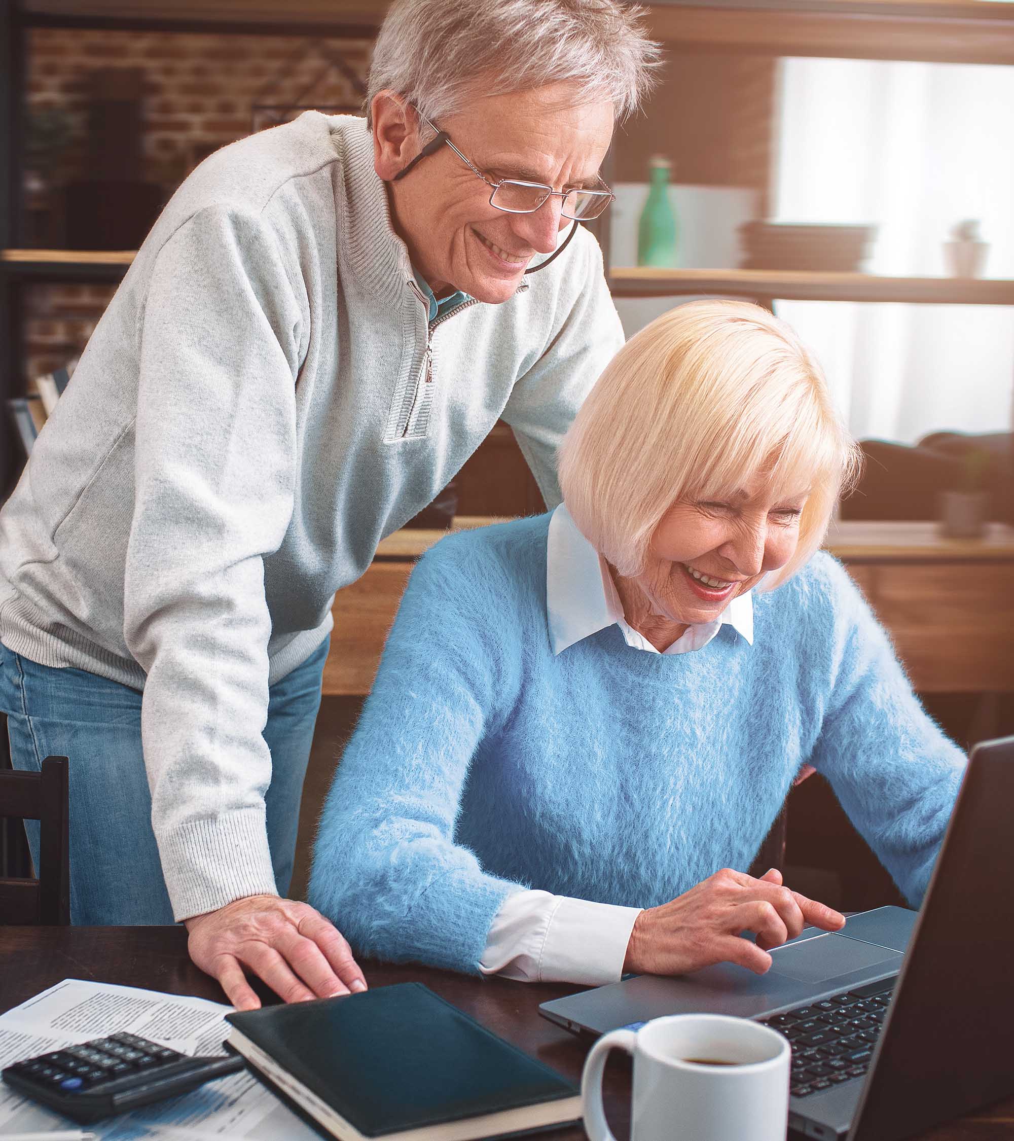 Couple looking at a laptop, satisfied with their decision