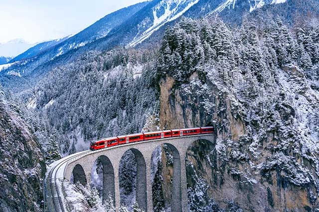 Train on a bridge with beautiful mountains in background