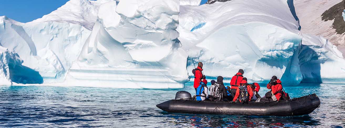 People on a zodiak near icebergs
