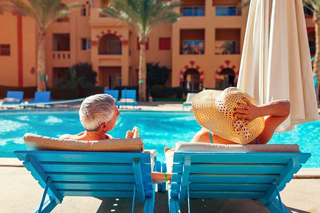 Couple relaxing by the pool at a resort.