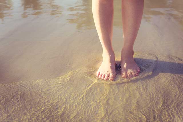 Relaxation travel is sometimes as simple as feet in the water on a beach.